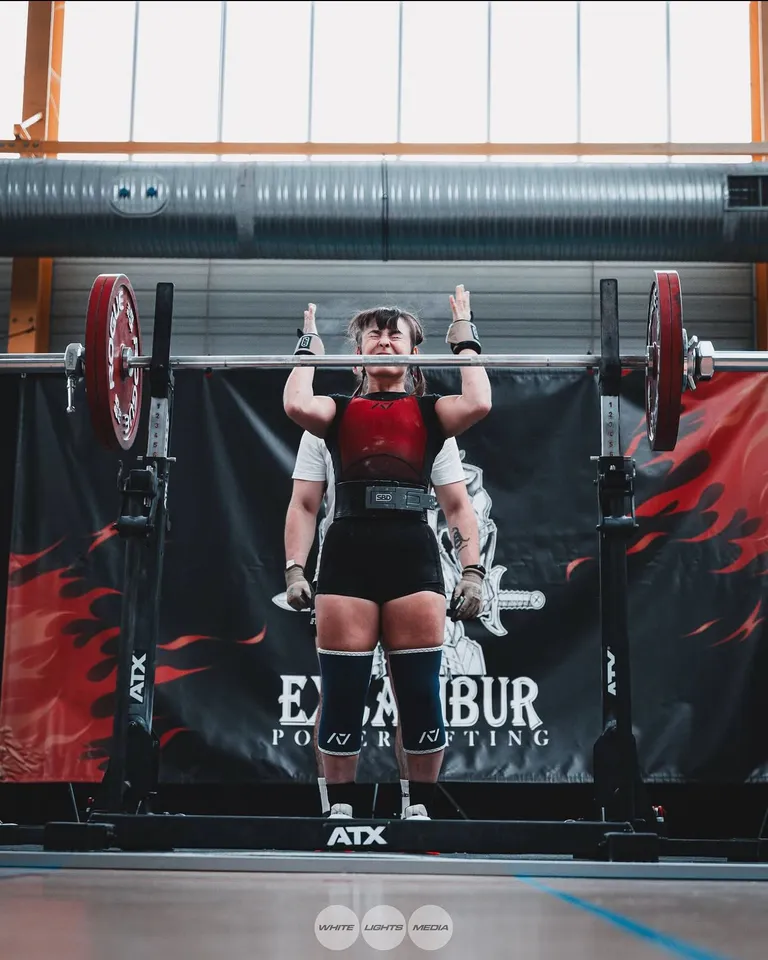 Un moment de concentration avant un squat lors de la compétition Excalibur. Photo @the.enora / @whitelightsmediafr.